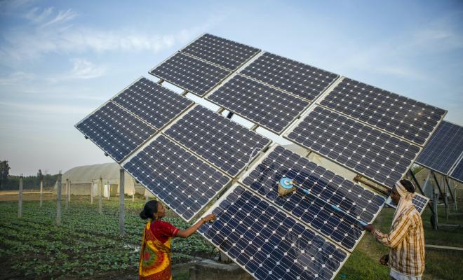 Farm workers clean the solar panels for better efficiency in India (cred IWMI) via Flickr